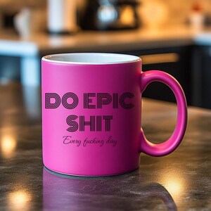 May include: A magenta ceramic mug with the text "DO EPIC SHIT" in black, with "Every fucking day" below. The mug has a white interior and a curved handle.