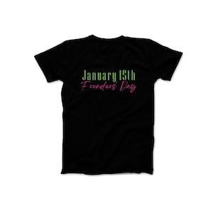 May include: Black t-shirt with the text "January 15th Founders' Day" in green and pink.
