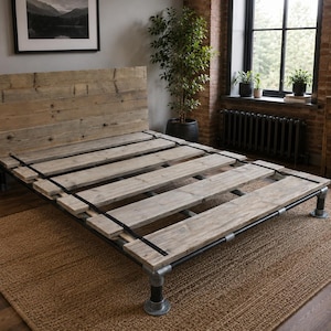 May include: A bed frame constructed from dark grey industrial metal piping and light-toned wooden planks. The design features a tall, rectangular wooden headboard made of horizontal boards and a platform base supported by four metal pipe legs.