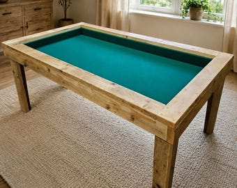 May include: A rectangular gaming table featuring a sturdy, light-toned natural wood frame with visible grain and a recessed, flat playing surface covered in a vibrant teal felt fabric. The table stands on four thick, straight wooden legs.