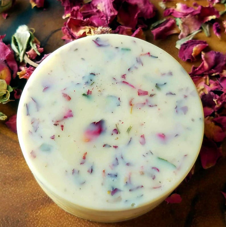 May include: A white soap bar with dried rose petals and herbs embedded in it.