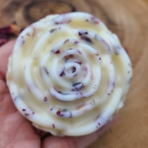 May include: A white rose-shaped soap with dried rose petals embedded in it.