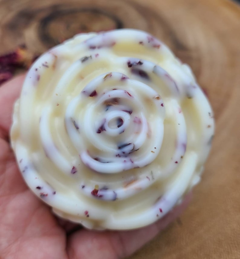 May include: A white rose-shaped soap with dried rose petals embedded in it.