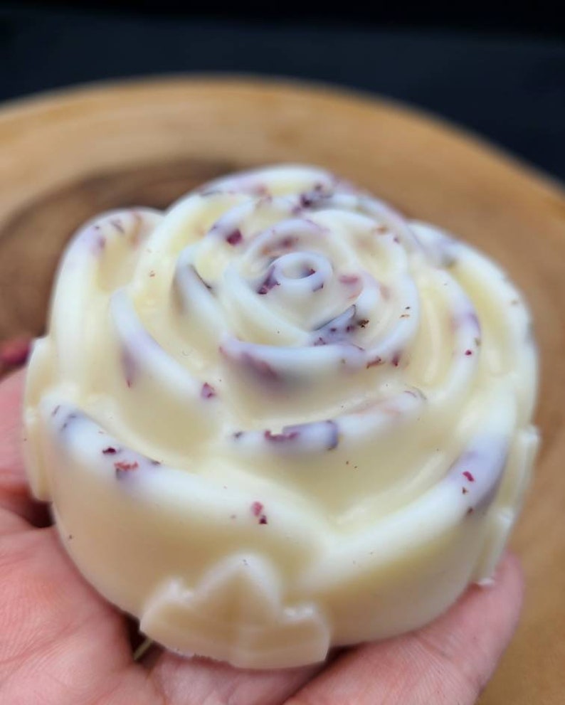 May include: A white rose-shaped soap with dried rose petals embedded in it.