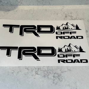 May include: Two black vinyl decals with the text "TRD OFF ROAD" and a mountain range graphic.