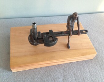 Bronze figure with found object. Title "Toil:Wrench"