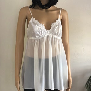 K&ouml;nnte beinhalten: Ein wei&szlig;er, durchsichtiger Slip mit einem Satin-Oberteil und Spitzenbesatz. Der Slip hat einen V-Ausschnitt und verstellbare Tr&auml;ger.