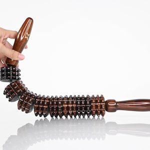 Può includere: Un rullo da massaggio in legno marrone con un manico e più ruote con punte. Il rullo è flessibile e può essere piegato in una forma curva.