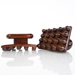 May include: Two dark brown wooden massage tools with a polished finish. Each tool features a rectangular base with multiple rounded nodes on the underside and a central handle on top for gripping, designed for manual body massage applications.