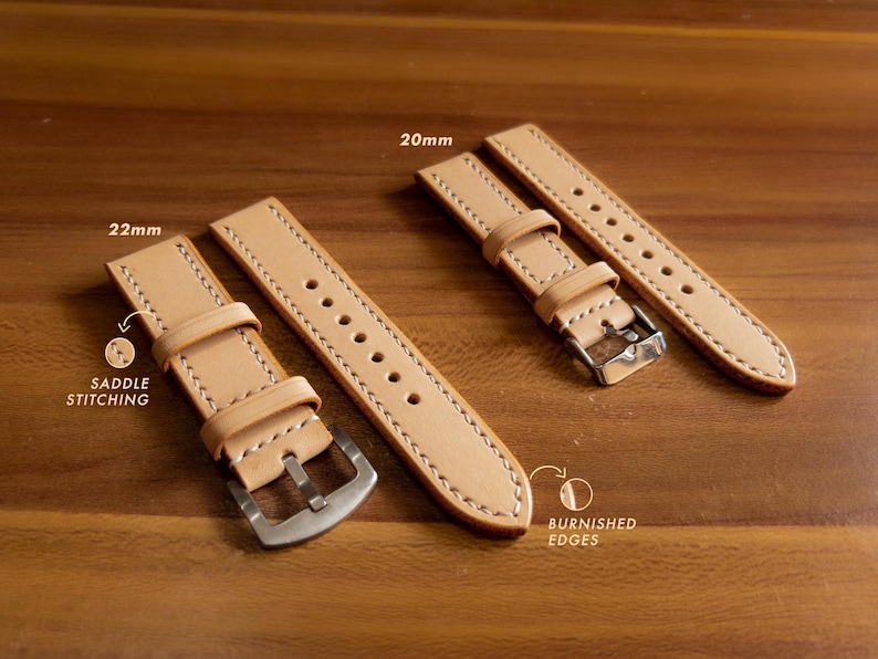 May include: Two leather watch straps in a light brown color with white stitching. The strap on the left is 22mm wide and the strap on the right is 20mm wide. Both straps have burnished edges and saddle stitching.