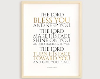 May include: A framed print with a white background and black text. The text reads "The Lord bless you and keep you. The Lord make his face shine on you and be gracious to you. The Lord turn his face toward you and give you peace." The text is in a gold font. The bottom of the print reads "Numbers 6:24-26".
