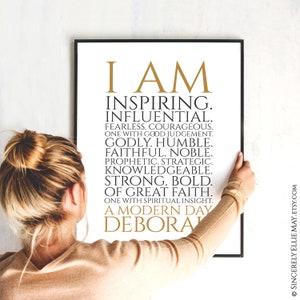 Peut inclure: Une impression encadr&eacute;e en noir et blanc avec du texte dor&eacute; qui dit "I AM INSPIRING. INFLUENTIAL. FEARLESS. COURAGEOUS. ONE WITH GOOD JUDGEMENT. GODLY. HUMBLE. FAITHFUL. NOBLE. PROPHETIC. STRATEGIC. KNOWLEDGEABLE. STRONG. BOLD. OF GREAT FAITH. ONE WITH SPIRITUAL INSIGHT. A MODERN DAY DEBORA"