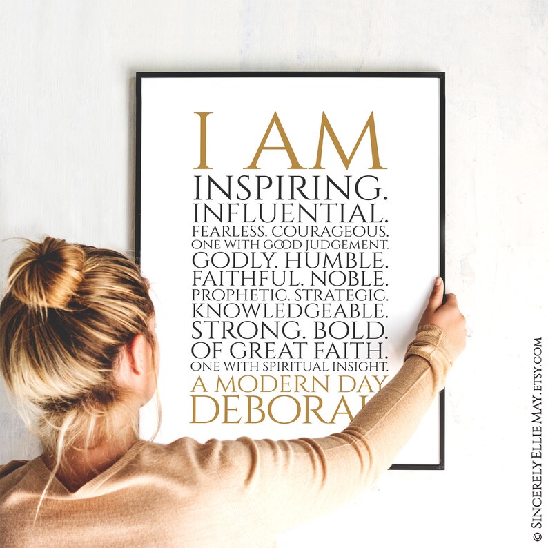 Peut inclure: Une impression encadr&eacute;e en noir et blanc avec du texte dor&eacute; qui dit "I AM INSPIRING. INFLUENTIAL. FEARLESS. COURAGEOUS. ONE WITH GOOD JUDGEMENT. GODLY. HUMBLE. FAITHFUL. NOBLE. PROPHETIC. STRATEGIC. KNOWLEDGEABLE. STRONG. BOLD. OF GREAT FAITH. ONE WITH SPIRITUAL INSIGHT. A MODERN DAY DEBORA"