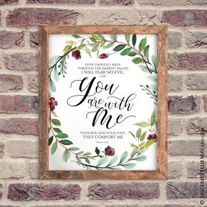 K&ouml;nnte beinhalten: Ein gerahmter Druck mit Holzrahmen, der den Text "You are with Me" in eleganter Schrift zeigt. Der Text ist von einem Aquarellkranz aus gr&uuml;nen Bl&auml;ttern und burgunderfarbenen Blumen umgeben. Der Druck enth&auml;lt einen Bibelvers.