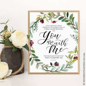 K&ouml;nnte beinhalten: Gerahmter Druck mit dem Text "You are with Me" in eleganter Schrift, umgeben von einem Aquarellkranz aus gr&uuml;nen Bl&auml;ttern und burgunderfarbenen Blumen. Der Druck enth&auml;lt einen Bibelvers und ist in einem hellen Holzrahmen gefasst.