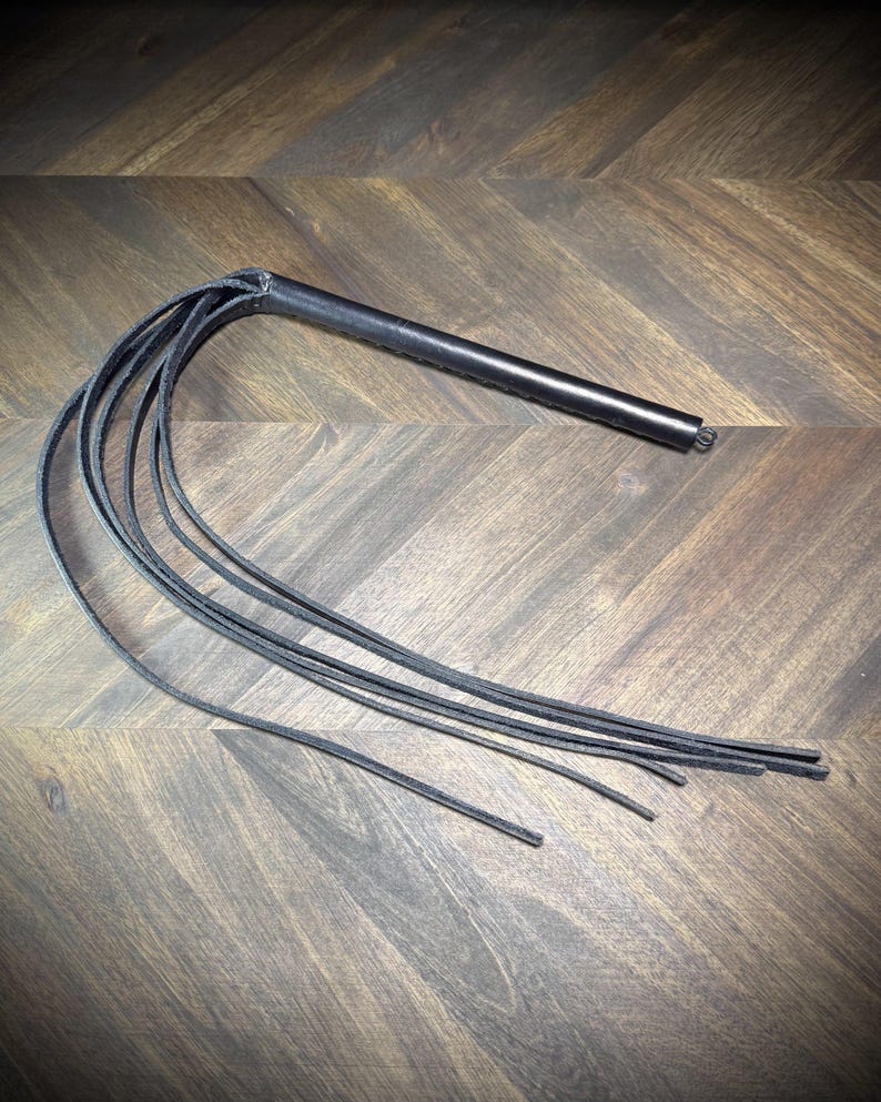 Alternate macro view of a hand-wrapped black leather handle, showcasing the heavy-duty stitch alignment and secure hardware attachment.