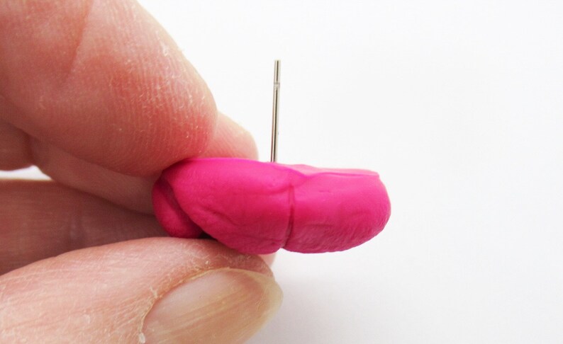 May include: A bright pink polymer clay earring with a silver post.