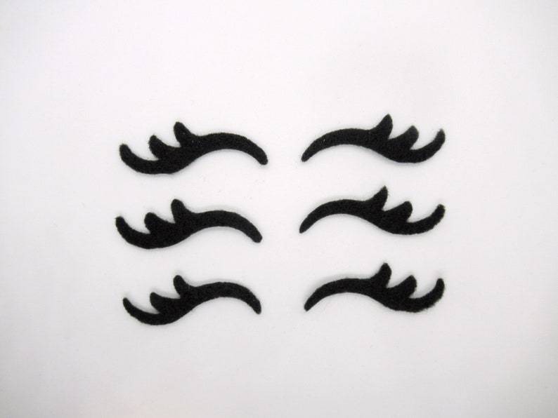 May include: Six black felt eyelashes, each with a different design, for crafting or decorating.