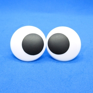 Peut inclure: Deux grands yeux globuleux blancs avec des pupilles noires, sur un fond bleu.