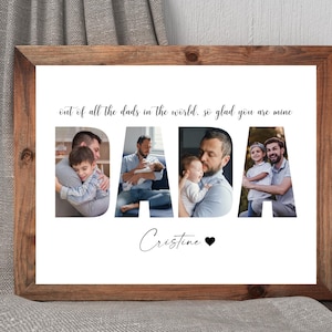 Op de afbeelding: Een ingelijst afdruk met een witte achtergrond en een zwarte inscriptie die luidt "out of all the dads in the world, so glad you are mine". De inscriptie wordt omringd door vier foto's van een vader en zijn kinderen. De foto's zijn zo gerangschikt dat ze het woord "DADA" vormen. De afdruk is gesigneerd met "Cristine" en een zwart hart.