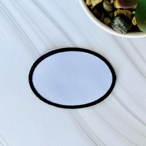 May include: A white oval patch with a black border. The patch is blank and ready to be customized.