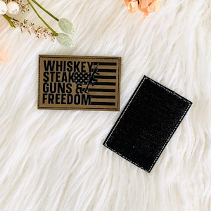 May include: A brown patch with the text "Whiskey, Steak, Guns & Freedom" in black, with a flag and rifle design. A separate black patch is also present.