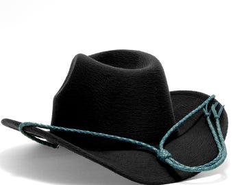 May include: A black cowboy hat with a textured finish and a turquoise chin strap. The hat has a classic, curved brim and a rounded crown. The chin strap is braided and features decorative tassels.