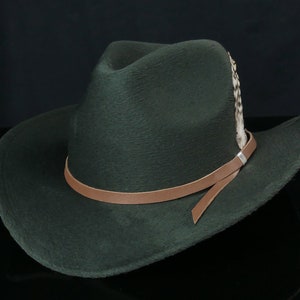 May include: A dark green felt cowboy hat with a brown leather band and a feather accent.