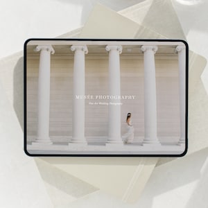 Może przedstawiać: Tablet cyfrowy wyświetlający zdjęcie panny młodej w białej sukni idącej między białymi kolumnami. Na tablecie widnieje tekst "MUS&Eacute;E PHOTOGRAPHY Fine Art Wedding Photography".
