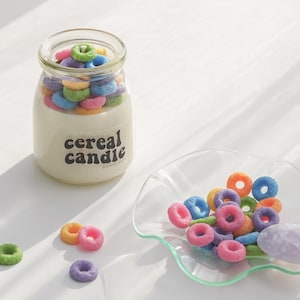 a lit fruit loops cereal candle filled with colorful cereal wax melts, cinnamon sticks, white and orange pumpkins, Ikea mini wood cutting board