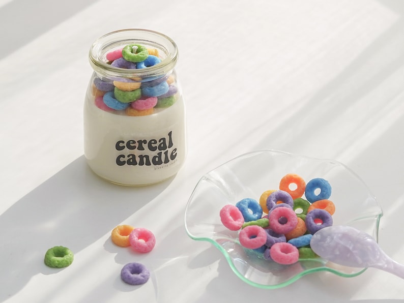 a lit fruit loops cereal candle filled with colorful cereal wax melts, cinnamon sticks, white and orange pumpkins, Ikea mini wood cutting board