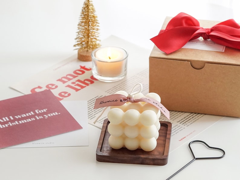 Christmas decor display on the table with handmade square bubble cube soy wax candle with bluewine studio ribbon, gift box, gold Christmas tree, thank you cards and heart shaped candle wick dipper on the desk.