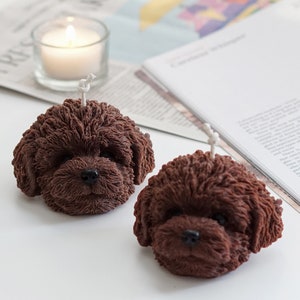 There are two dark brown chocolate dog shaped with fur details and articles on the minimal ikea table.