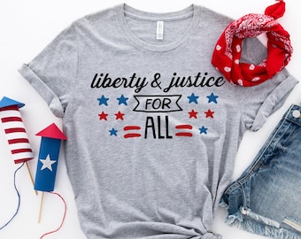 May include: Gray t-shirt with the text "liberty & justice for all" in black lettering. The text is surrounded by red, white, and blue stars.