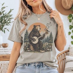 Camiseta Comfort Colors con estampado de oso y pájaro con banjo / Camiseta retro con gráficos de animales y música folk / Regalo para amantes de la naturaleza / Arte country bluegrass / Unisex