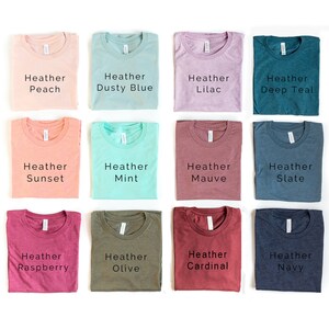 May include: A collection of 12 folded t-shirts in various heather colors, including peach, dusty blue, lilac, deep teal, sunset, mint, mauve, slate, raspberry, olive, cardinal, and navy.