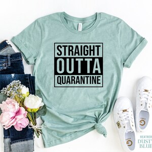 May include: A light blue t-shirt with the text "STRAIGHT OUTTA QUARANTINE" in a black box.