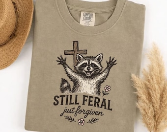 Comfort Colors Still Feral Just Forgiven T-Shirt, Funny Christian Raccoon Graphic Tee, Wild Believer Faith Shirt, Sassy Humor Gift
