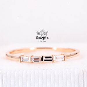 Op de afbeelding: Een delicate gouden ring met vijf baguette-geslepen diamanten in een rij gezet. De ring is simpel en elegant, perfect voor dagelijks gebruik.