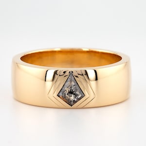 May include: A gold band ring with a geometric design featuring a dark gray diamond in the center.