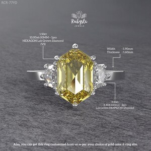 May include: A silver ring featuring a large, yellow hexagon-cut lab-grown diamond, flanked by two smaller, white trapezoid-cut diamonds. The ring's width is 1.90mm and thickness is 1.60mm. The ring can be customized. The text "Rubysta Jewels" is visible.