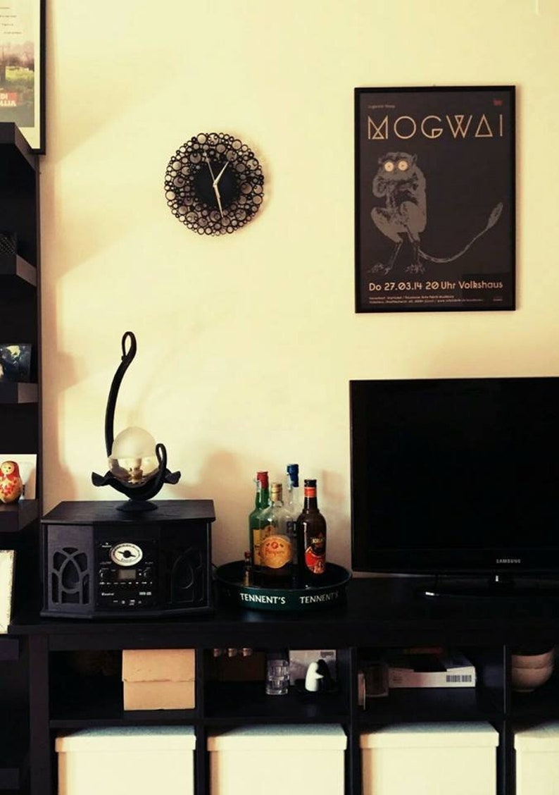 foto di una stanza dove è presente l'orologio appeso e altri particolari come un quadro e dei mobili