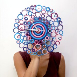 foto dove è presente una donna che ha il volto coperto dall'orologio di 28 cm