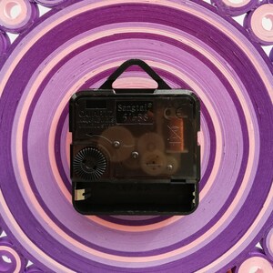 foto del meccanismo dell'orologio che è silenzioso e dotato di gancio. funziona con batteria AA