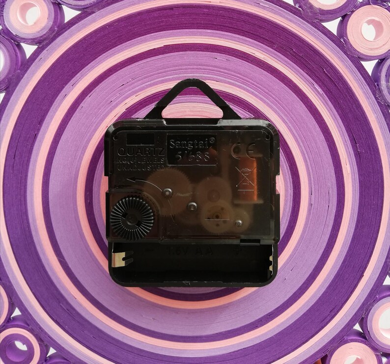 foto del meccanismo dell'orologio che è silenzioso e dotato di gancio. funziona con batteria AA