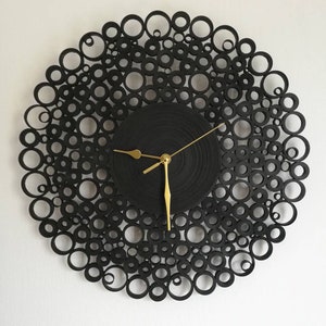 orologio da parete creato con cartoncini neri.il diametro è di 38 cm e le lancette sono dorate