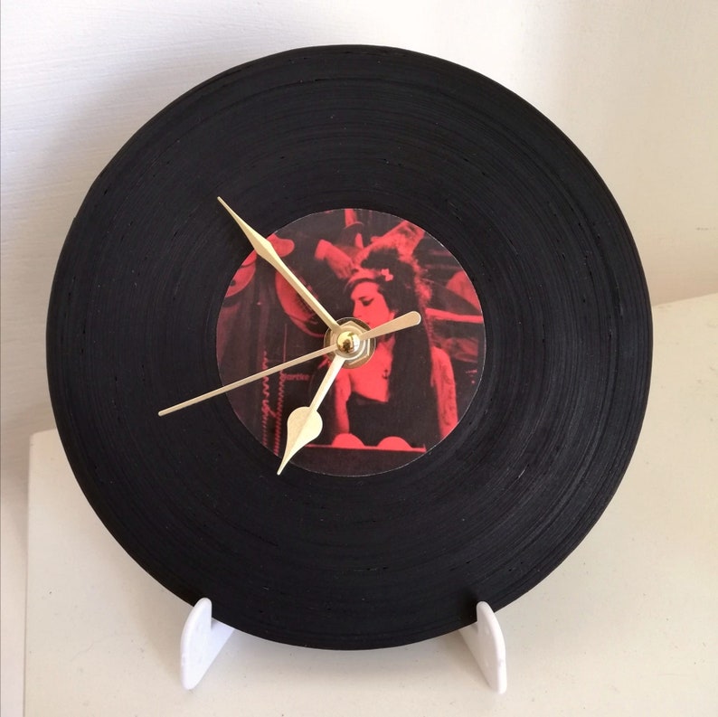 orologio da tavolo a forma di vinile nero. il supporto  in plastica bianco