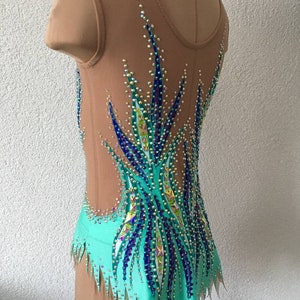 May include: A turquoise leotard with a sheer bodice and a design of blue and green rhinestones. The leotard has a jagged hemline.