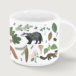 Könnte beinhalten: Weißer Keramikbecher mit Illustrationen von Waldelementen, darunter ein Dachs, ein Fuchs, Insekten, Blätter und Blumen. Der Becher hat einen gebogenen Griff und eine glatte Oberfläche, ideal für Kaffee oder Tee.