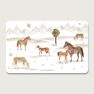 Può includere: Illustrazione ad acquerello di un paesaggio montano con cinque cavalli. I cavalli sono marroni, bianchi e neri con macchie marroni, bianche e nere. I cavalli sono in piedi in un campo con erba verde e fiori. Le montagne sono sullo sfondo e sono bianche con la neve in cima. Il sole splende nel cielo. Il testo "www.HERZundPAPIER.com" è nella parte inferiore dell'immagine.